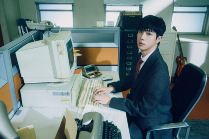 Jin works hard at the office in new ‘Happy’ teasers